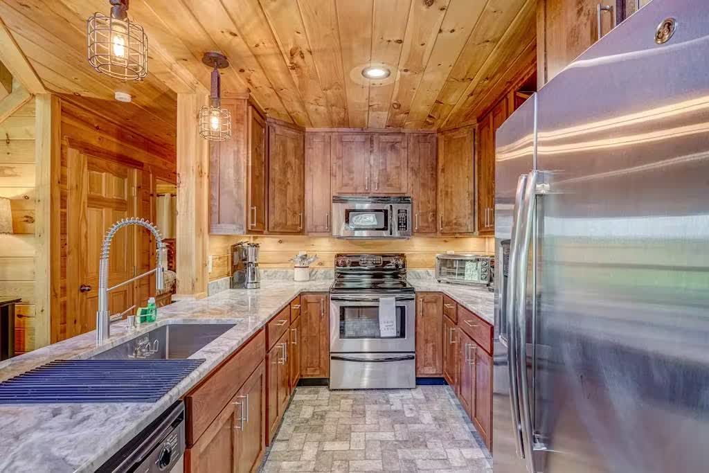 Galley kitchen with marble counters and stainless appliances